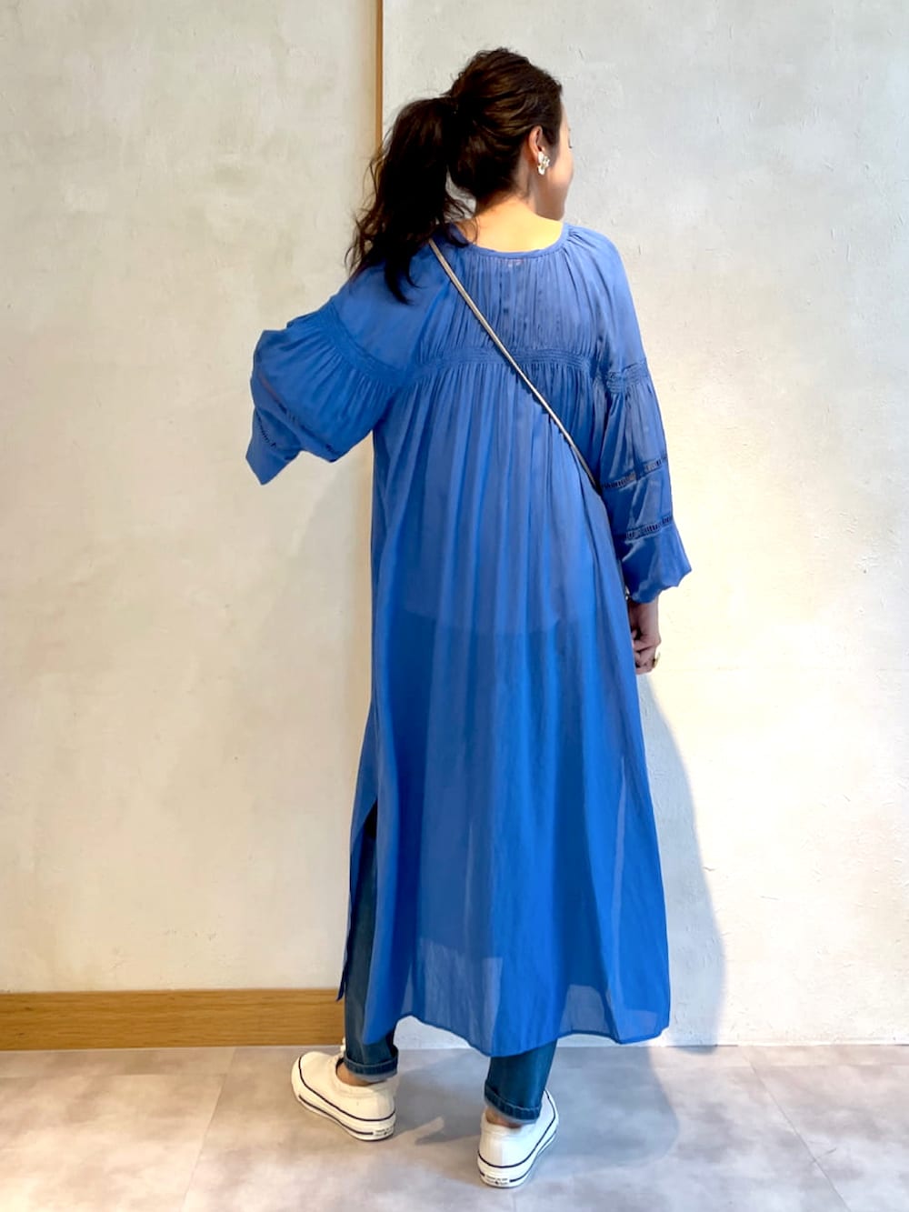 ブルー系のワンピース、ホワイト系のスニーカーを着用したレディースの春コーディネートの3枚目の写真