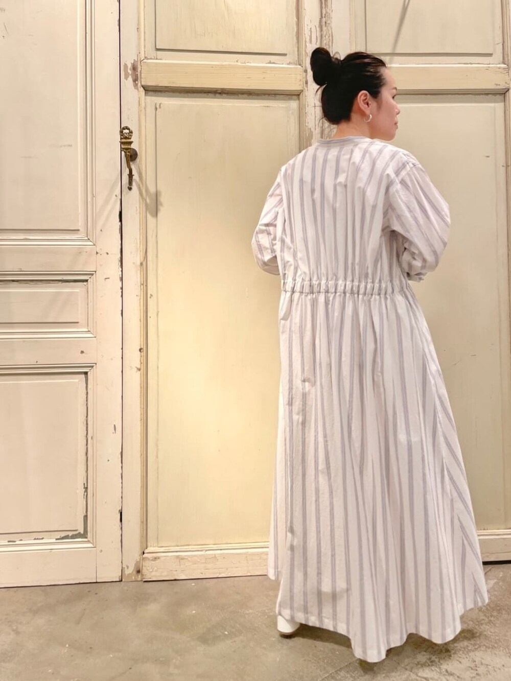 ブルー系のワンピース、ホワイト系のシャツ/ブラウス、ホワイト系のデニムパンツを着用したレディースの春コーディネートの3枚目の写真