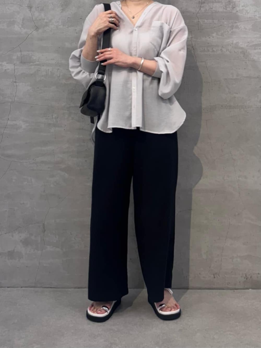 ブラック系のその他パンツ、ブラック系のショルダーバッグ、ホワイト系のサンダルを着用したレディースの冬コーディネートの5枚目の写真