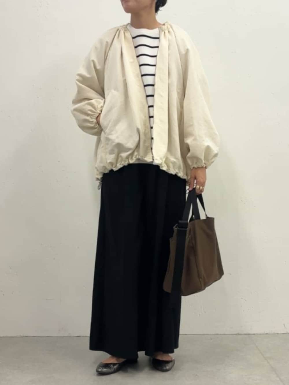 ホワイト系のノーカラージャケット、ブラック系のその他パンツ、ホワイト系のニット/セーターを着用したレディースの冬コーディネートの3枚目の写真