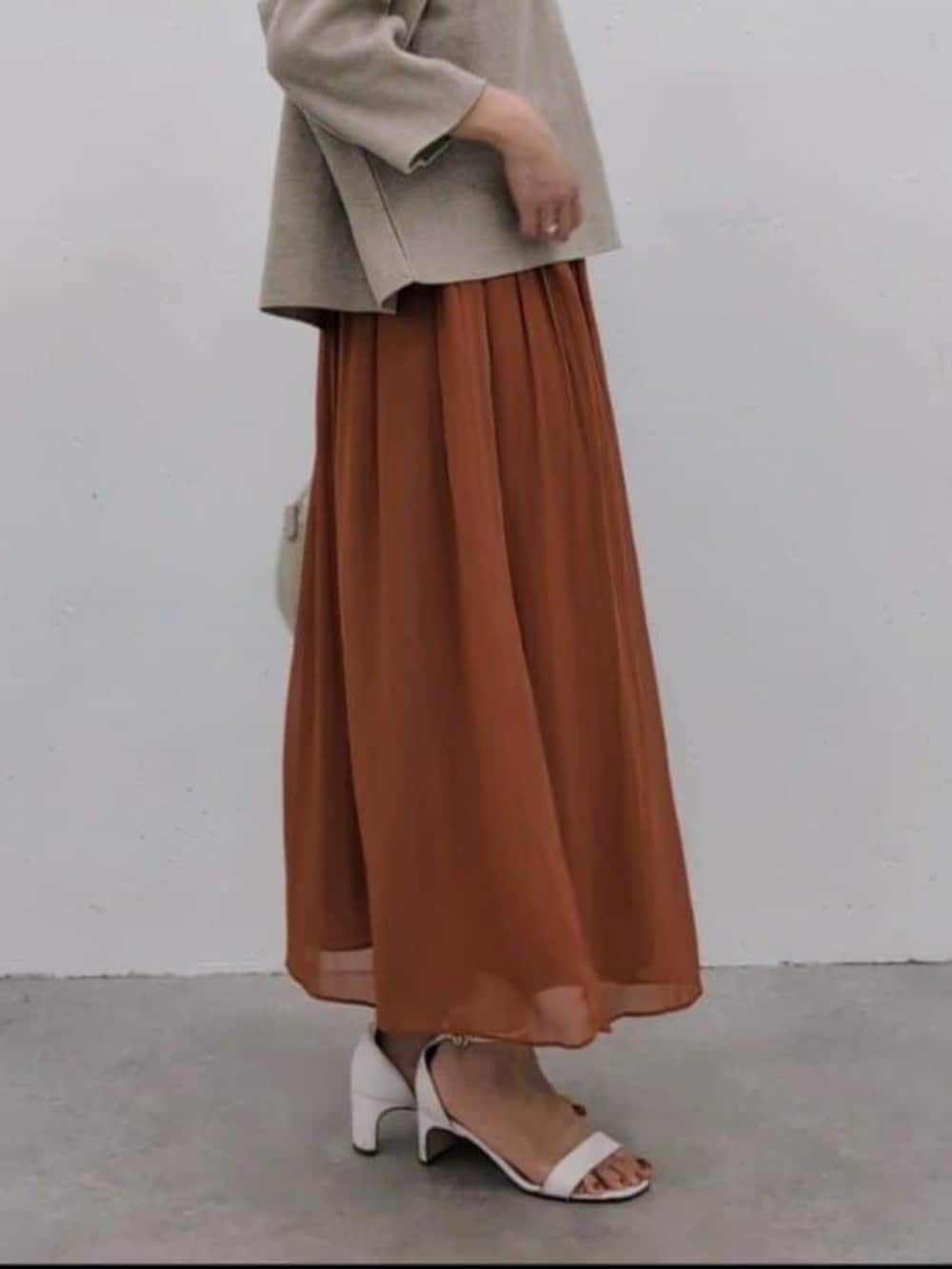 グレー系のボストンバッグ、オレンジ系のその他パンツ、ベージュ系のニット/セーターを着用したレディースの冬コーディネートの6枚目の写真