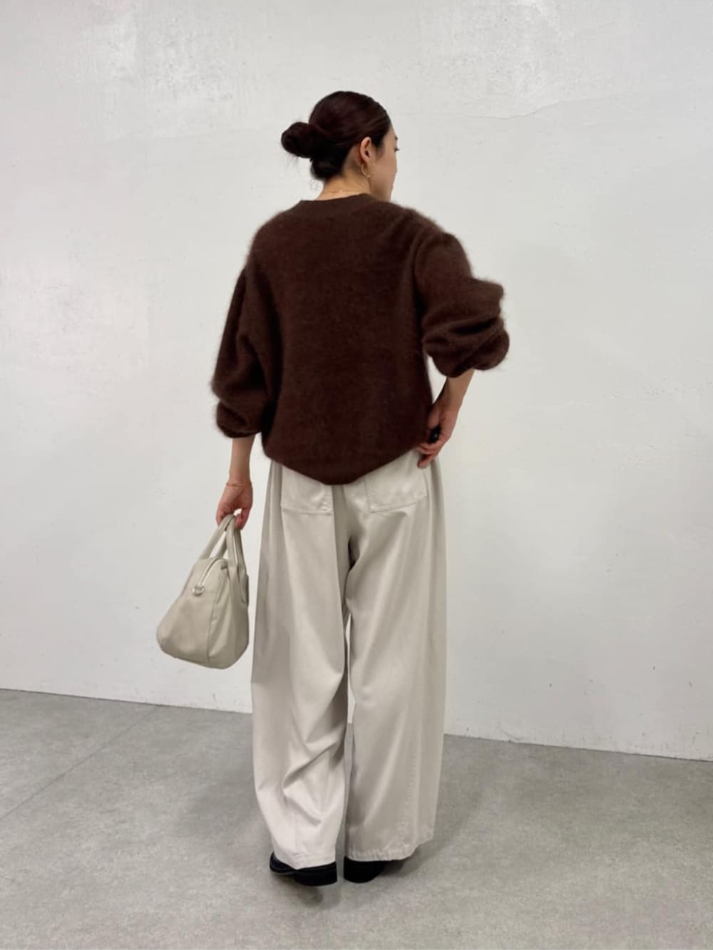 ブラック系のローファー、ホワイト系のその他パンツ、ブラウン系のニット/セーターを着用したレディースの秋コーディネートの6枚目の写真