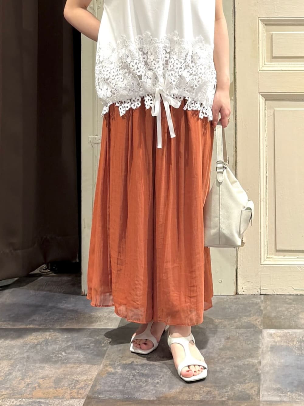 ホワイト系のトートバッグ、オレンジ系のその他パンツ、ホワイト系のTシャツ/カットソーを着用したレディースの春コーディネートの7枚目の写真
