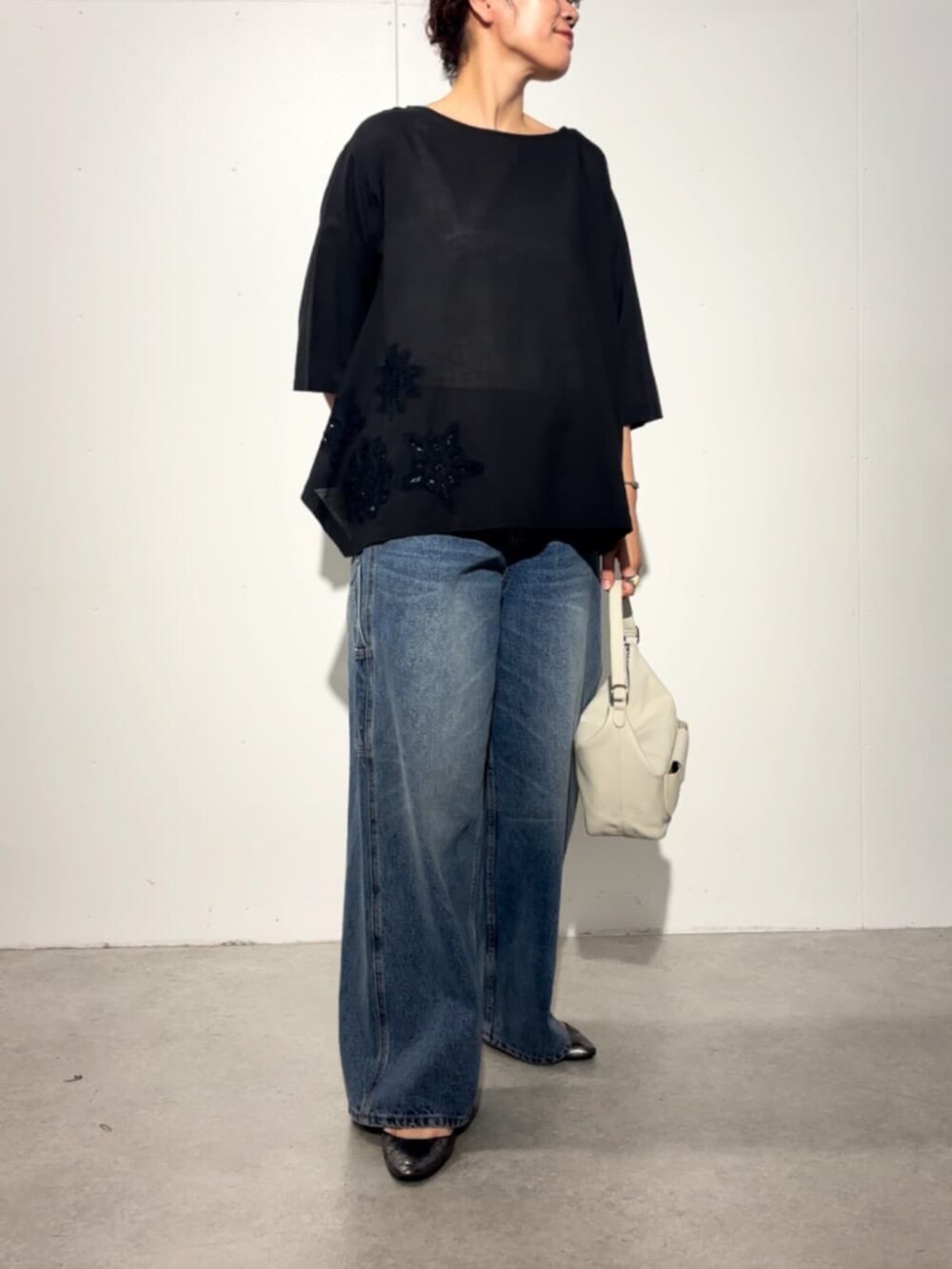 ホワイト系のトートバッグ、ブルー系のその他パンツ、ブラック系のシャツ/ブラウスを着用したレディースの春コーディネートの2枚目の写真