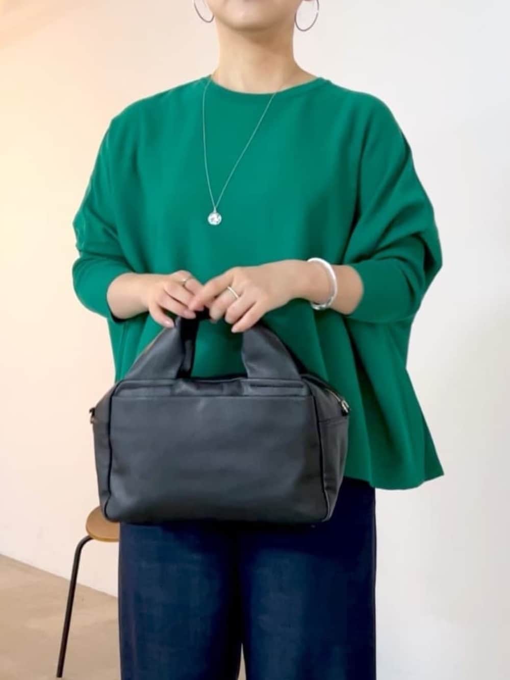 ブルー系のその他パンツ、ブラック系のボストンバッグ、グリーン系のニット/セーターを着用したレディースの夏コーディネートの7枚目の写真