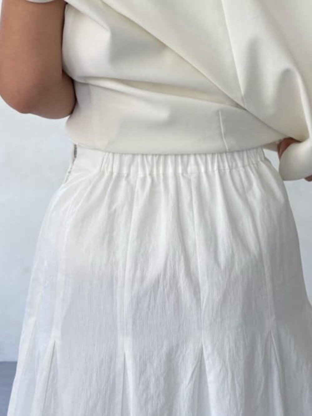 グレー系のハンドバッグ、ホワイト系のスカート、ホワイト系のシャツ/ブラウスを着用したレディースの春コーディネートの6枚目の写真