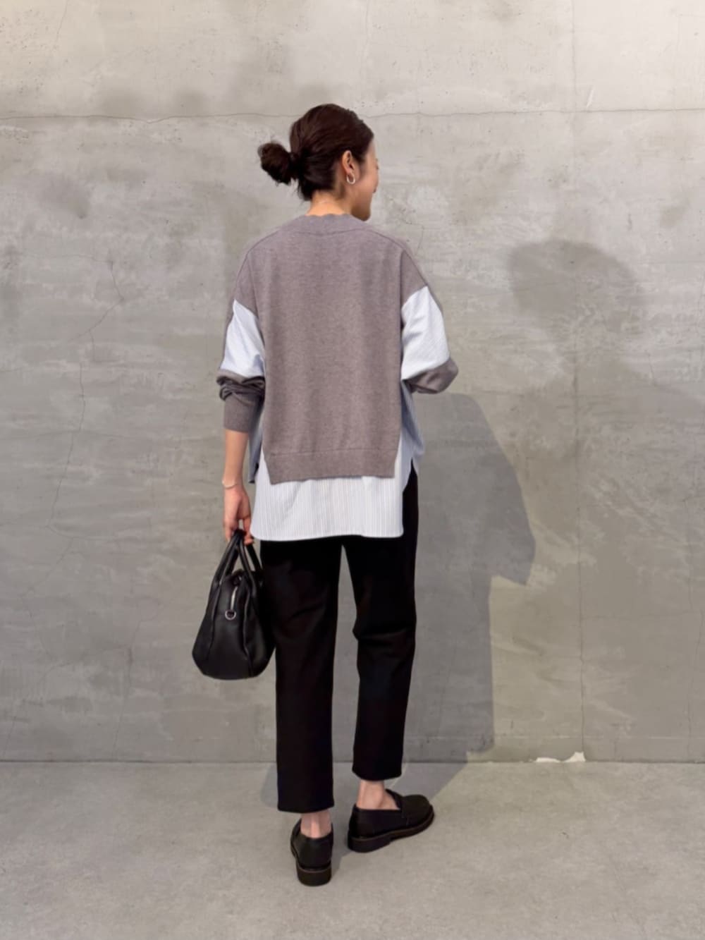 グレー系のニット/セーター、ブラック系のその他パンツ、ブラック系のローファーを着用したレディースの秋コーディネートの2枚目の写真