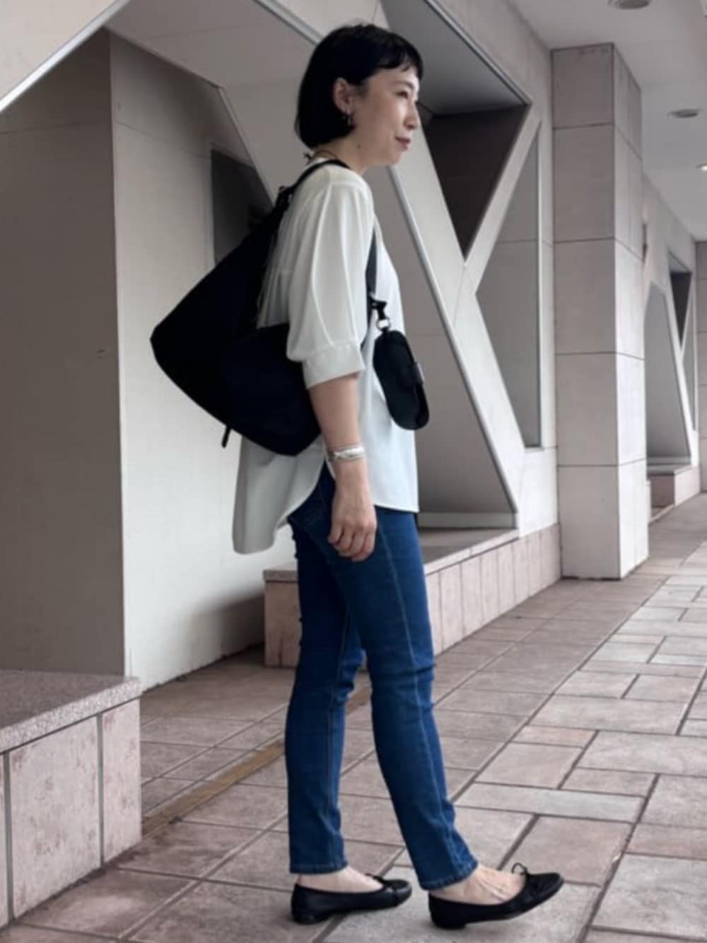 ブルー系のデニムパンツ、ホワイト系のTシャツ/カットソー、シルバー系のリングを着用したレディースの夏コーディネートの3枚目の写真