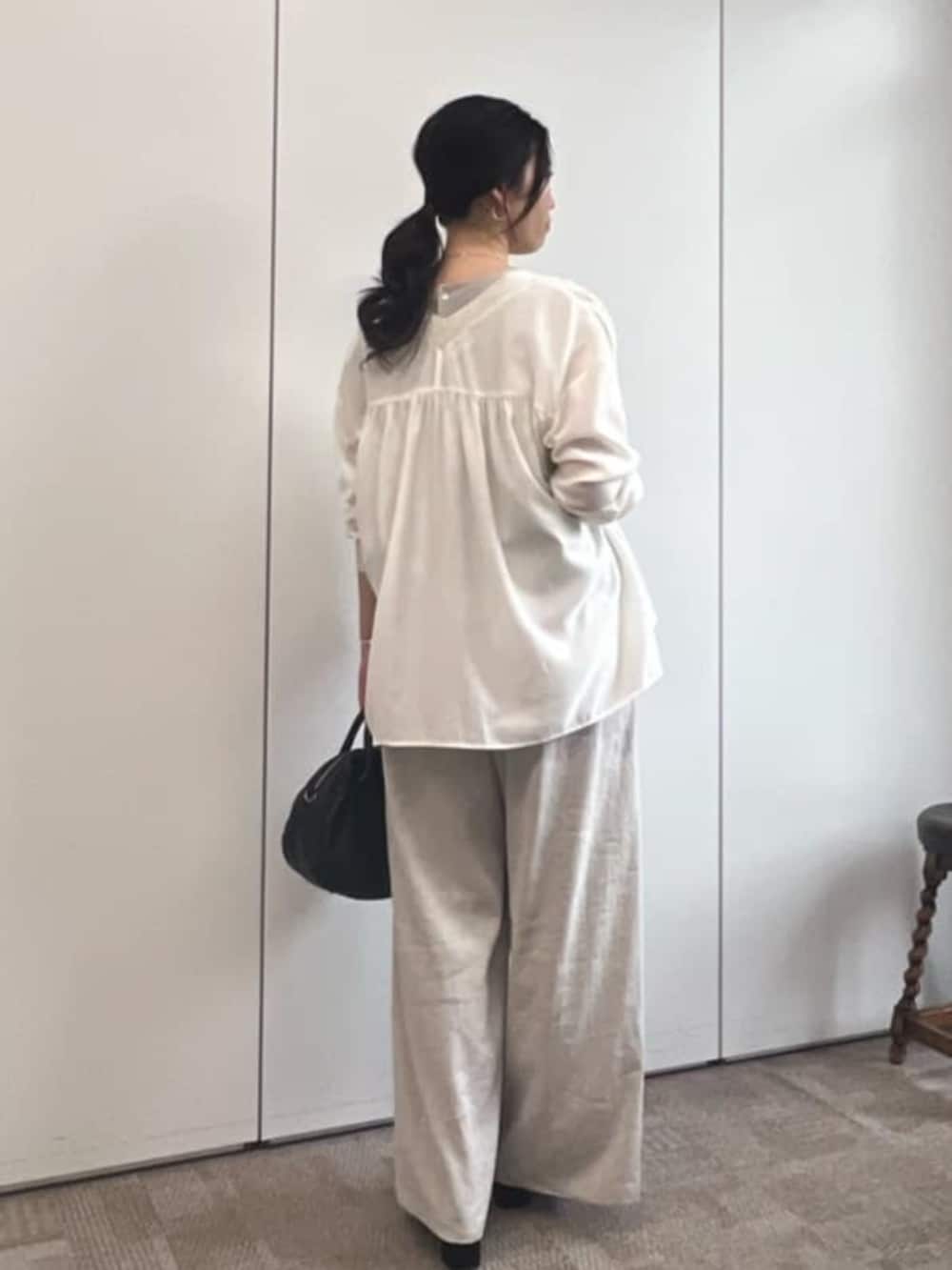 ブラック系のボストンバッグ、ホワイト系のシャツ/ブラウス、ベージュ系のシャツ/ブラウスを着用したレディースの冬コーディネートの3枚目の写真