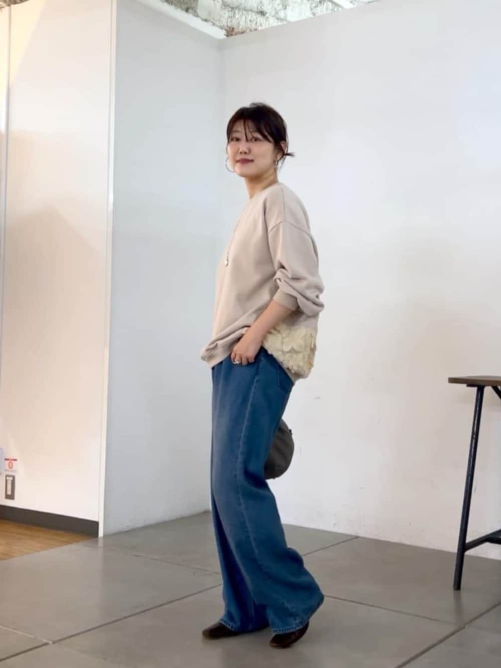グレー系のトートバッグ、ホワイト系のTシャツ/カットソーを着用したレディースの秋コーディネートの2枚目の写真
