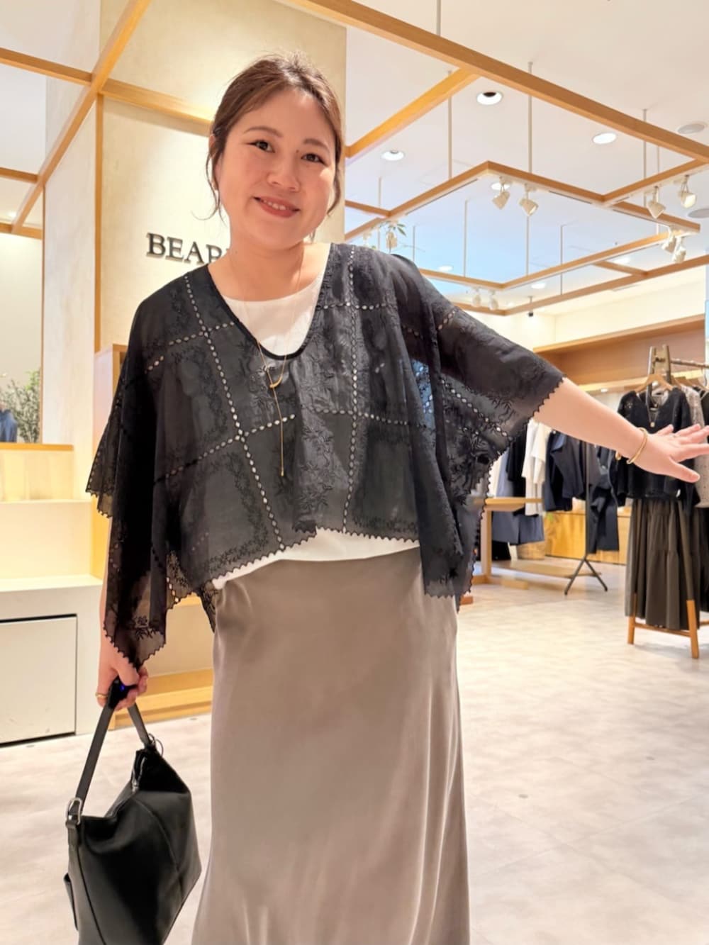 グリーン系のスカート、ブラック系のシャツ/ブラウス、ブラック系のスニーカーを着用したレディースの春コーディネートの7枚目の写真