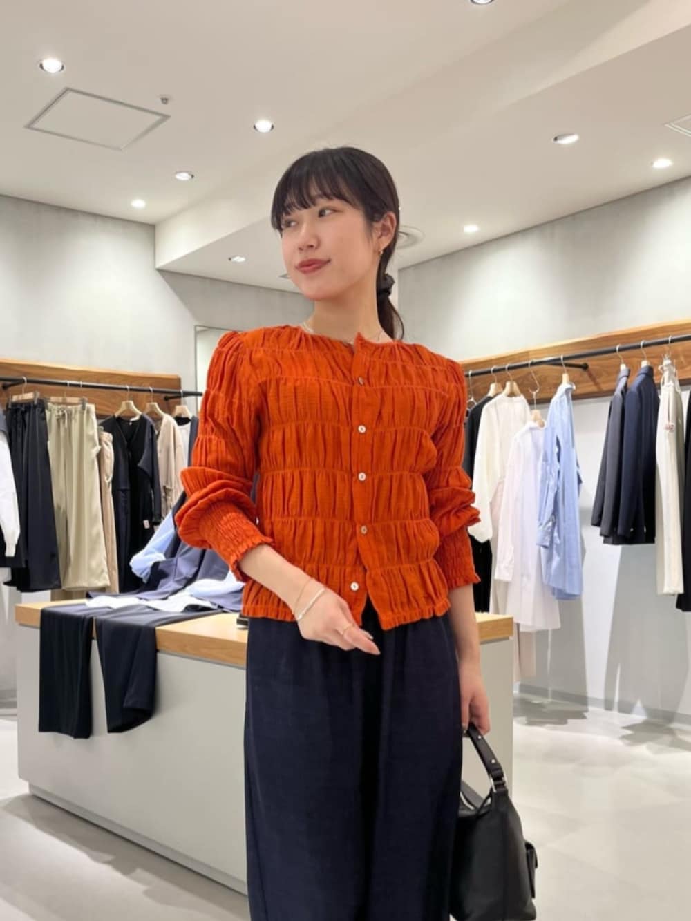 ブルー系のその他パンツ、オレンジ系のシャツ/ブラウスを着用したレディースの春コーディネートの8枚目の写真