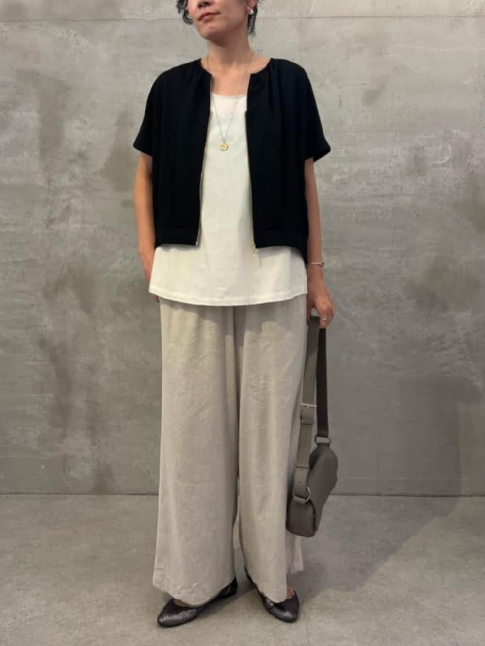ベージュ系のその他パンツ、ホワイト系のシャツ/ブラウス、ブラック系のベストを着用したレディースの春コーディネートの6枚目の写真