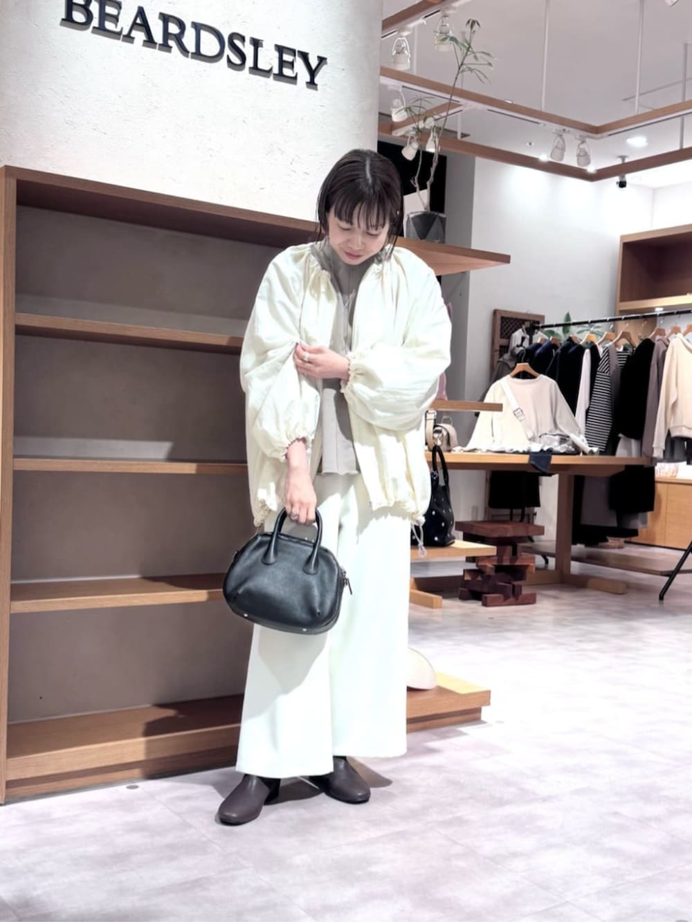 ブラック系のボストンバッグ、ブラウン系のTシャツ/カットソー、ホワイト系のその他パンツを着用したレディースの冬コーディネートの2枚目の写真