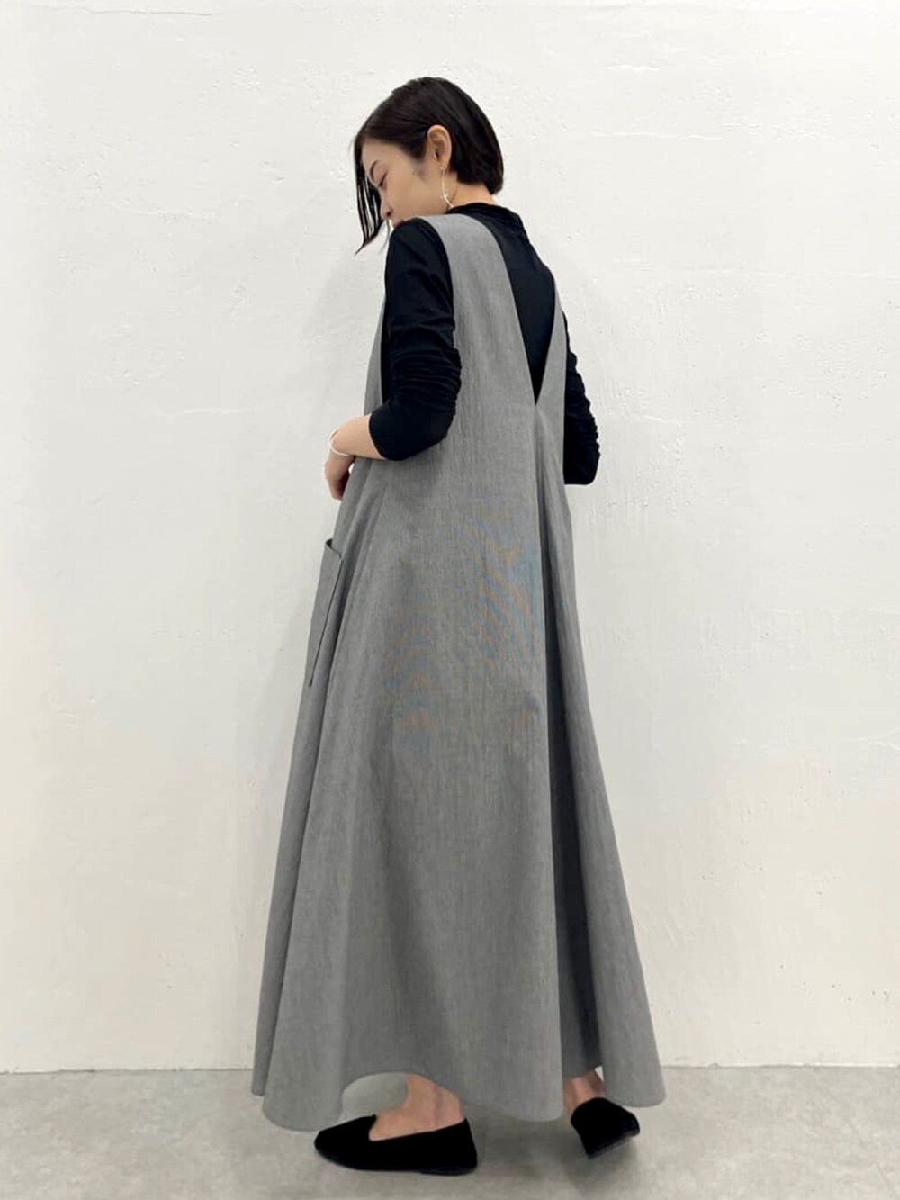 グレー系のワンピース、ブラック系のTシャツ/カットソーを着用したレディースの春コーディネートの2枚目の写真