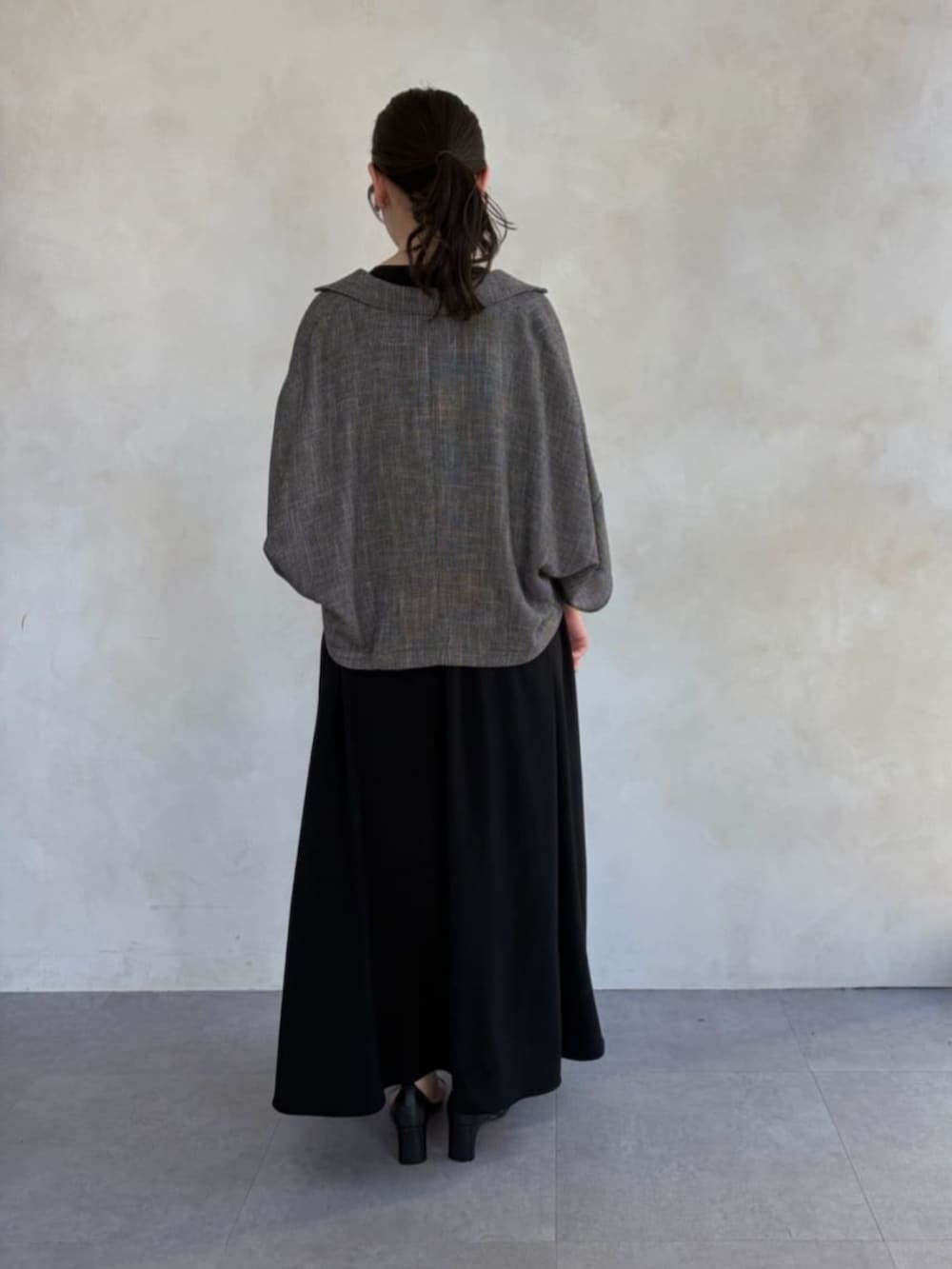 ブラック系のワンピース、ベージュ系のテーラードジャケットを着用したレディースの春コーディネートの3枚目の写真