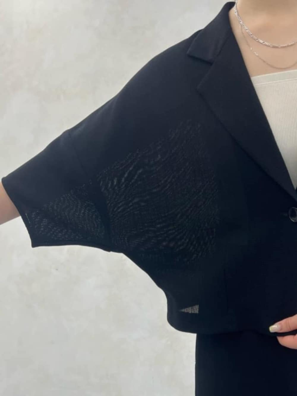 グレー系のハンドバッグ、ブラック系のテーラードジャケット、ブラック系のスカートを着用したレディースの春コーディネートの6枚目の写真