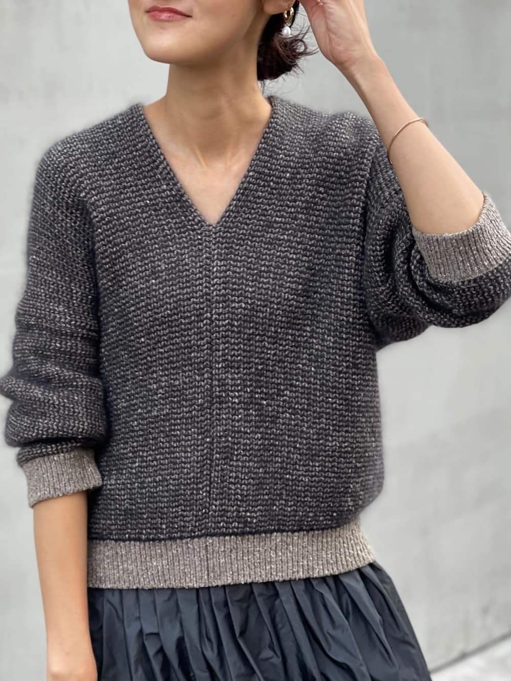 グレー系のスカート、ブルー系のチェスターコート、ブラウン系のニット/セーターを着用したレディースの秋コーディネートの3枚目の写真