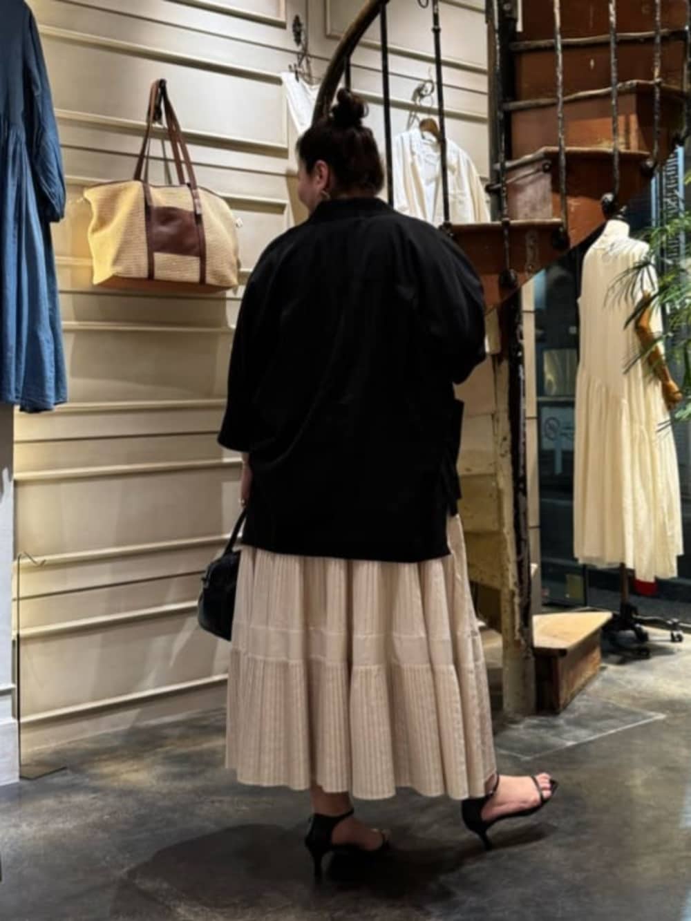 ホワイト系のスカート、ブラック系のテーラードジャケットを着用したレディースの春コーディネートの4枚目の写真