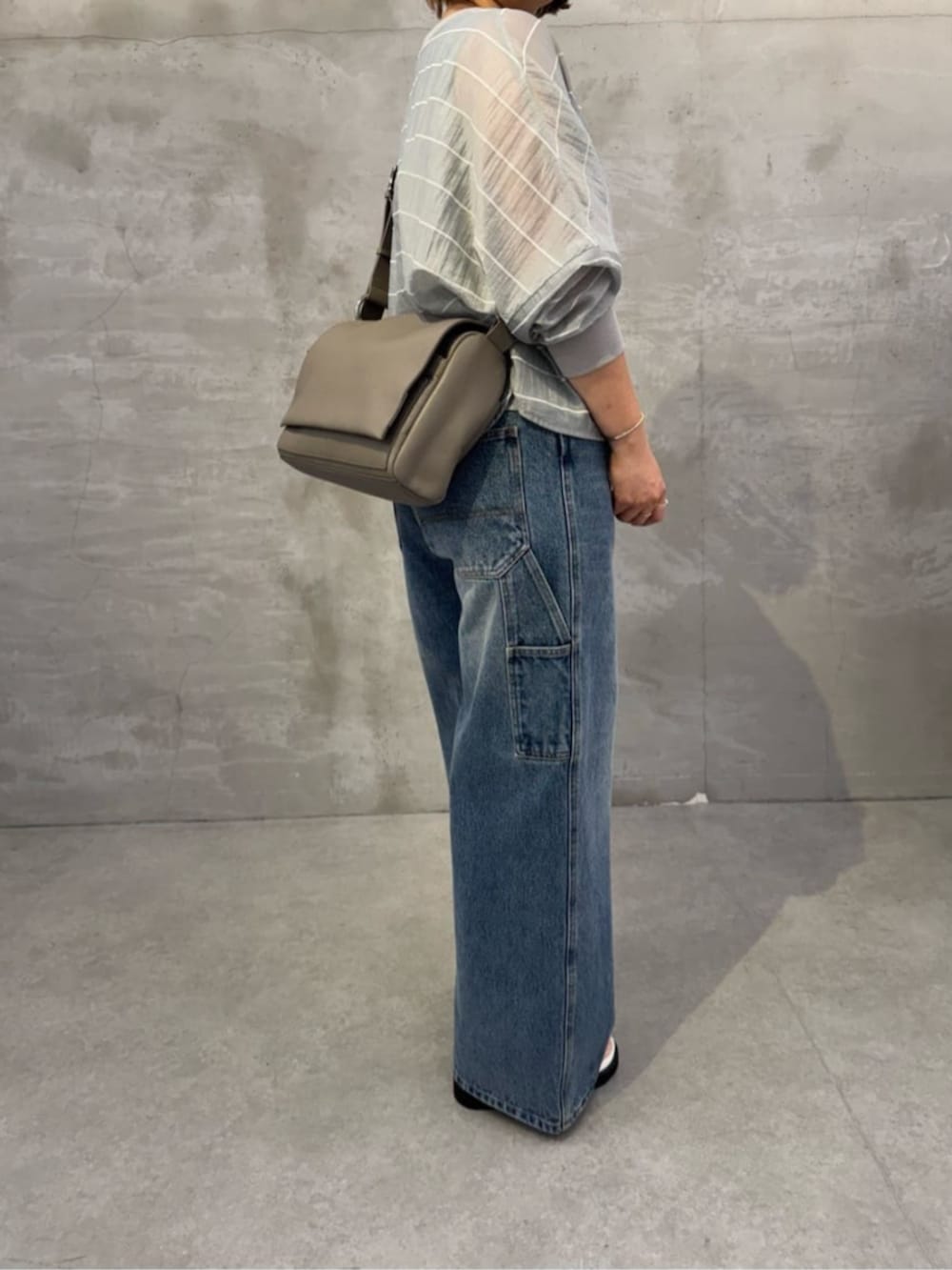 ブルー系のその他パンツ、ホワイト系のサンダル、グレー系のシャツ/ブラウスを着用したレディースの春コーディネートの4枚目の写真