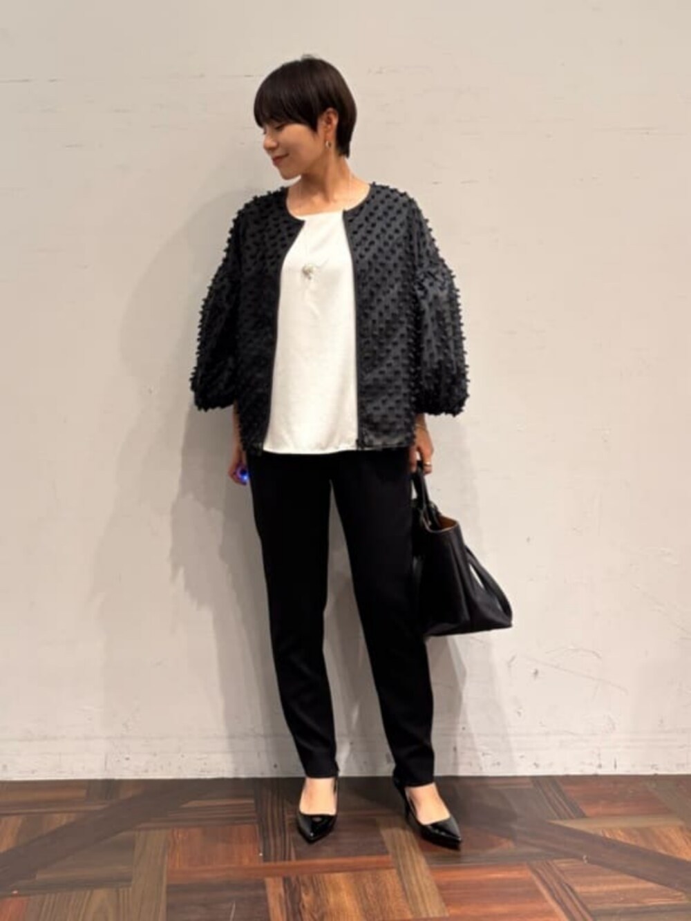 ブラック系のその他パンツ、ブラック系のノーカラージャケットを着用したレディースの夏コーディネートの2枚目の写真
