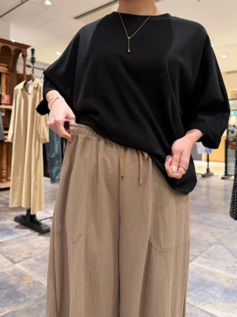 ベージュ系のその他パンツ、ブラック系のTシャツ/カットソーを着用したレディースの春コーディネートの8枚目の写真