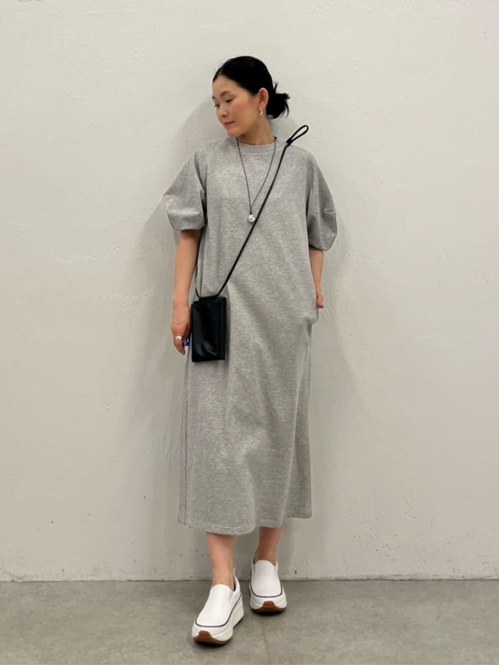 ブラック系のショルダーバッグ、グレー系のワンピース、シルバー系のリングを着用したレディースの冬コーディネートの2枚目の写真