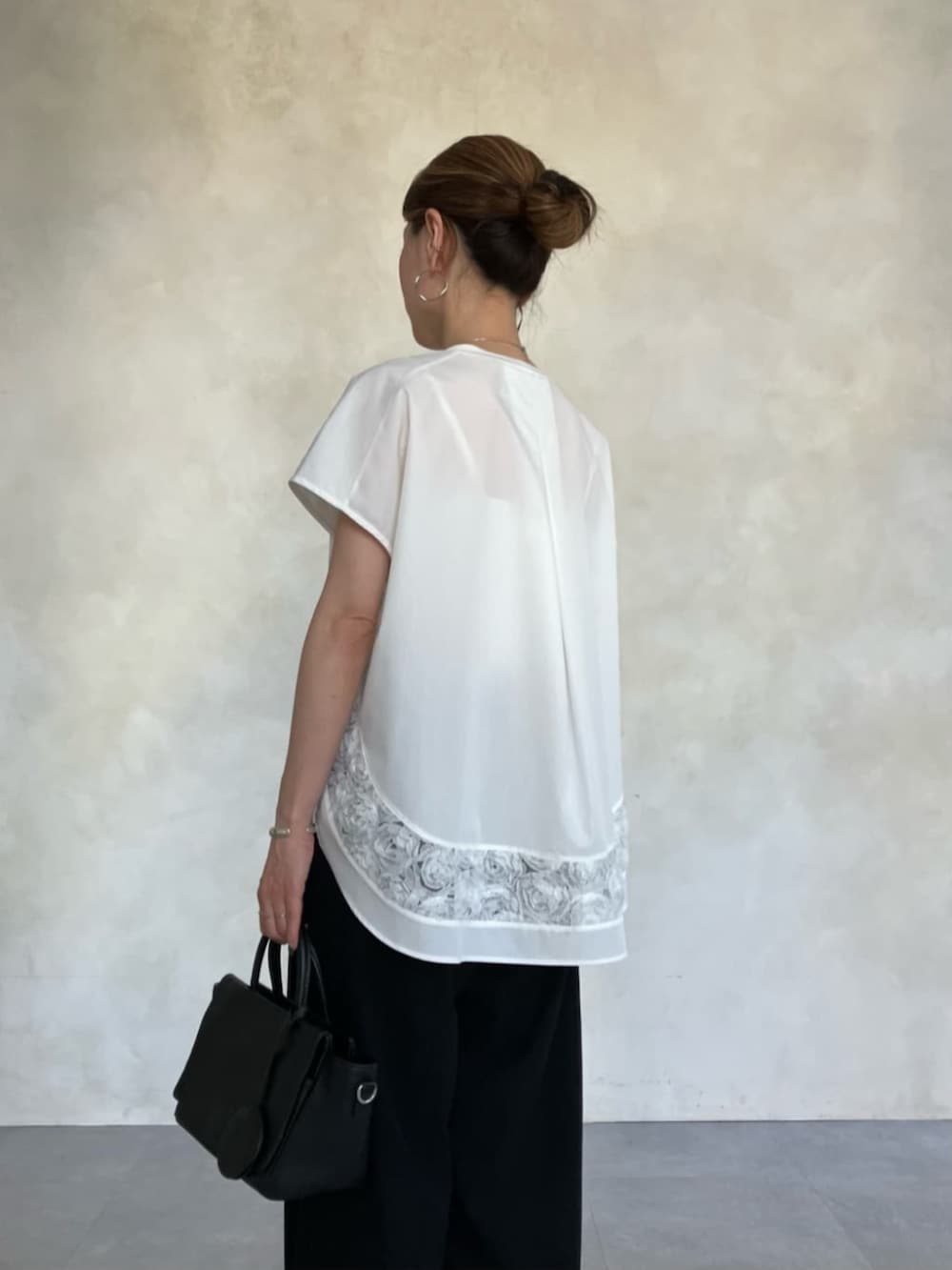 ブラック系のハンドバッグ、ホワイト系のTシャツ/カットソーを着用したレディースの春コーディネートの8枚目の写真