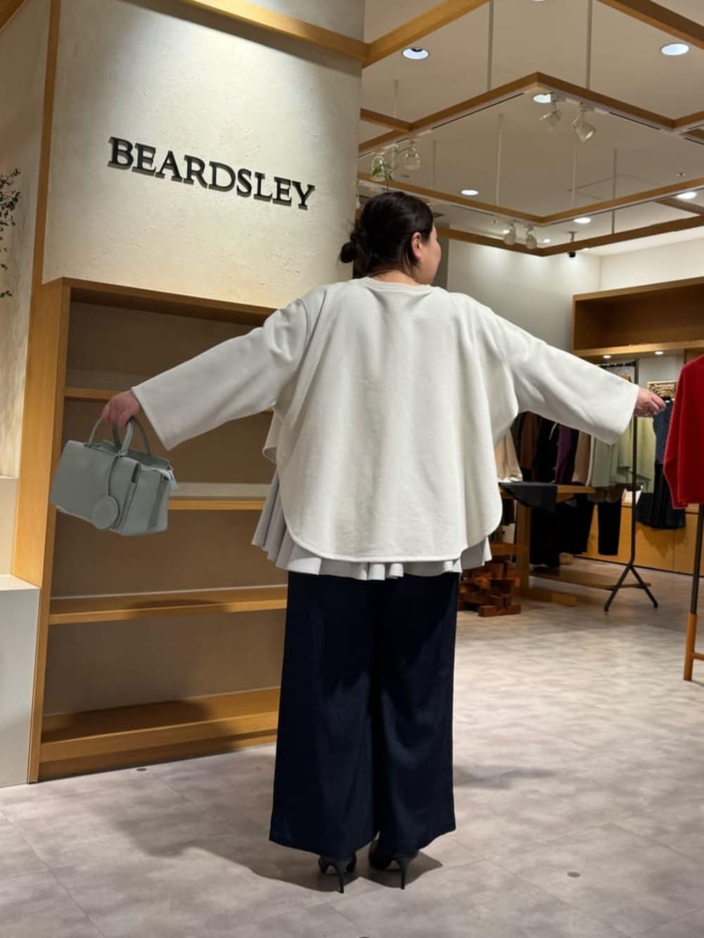 ブルー系のその他パンツ、グリーン系のハンドバッグ、ホワイト系のTシャツ/カットソーを着用したレディースの冬コーディネートの5枚目の写真