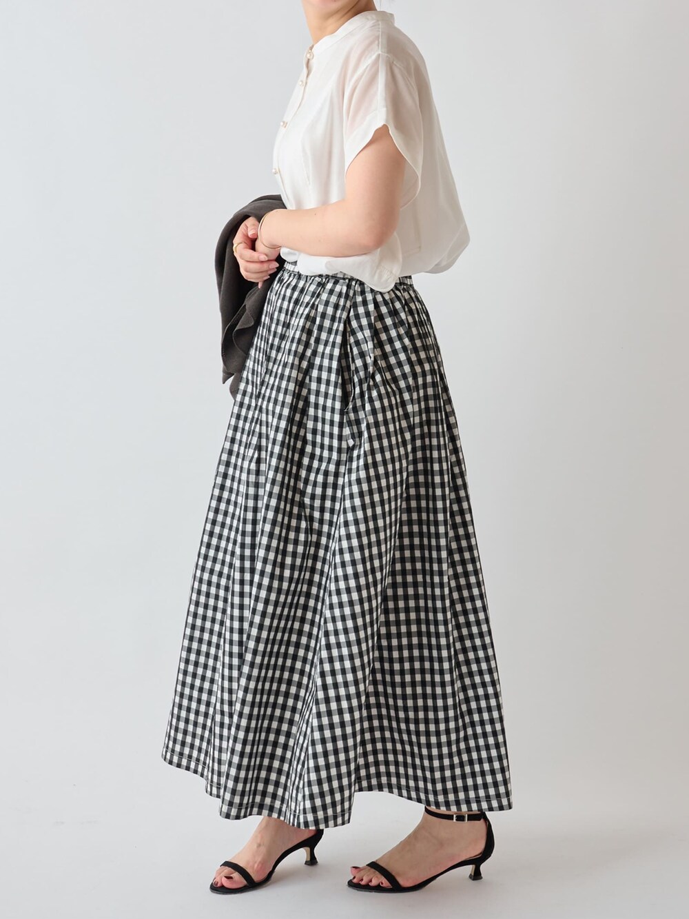 グレー系のカーディガン/ボレロ、ホワイト系のシャツ/ブラウス、ホワイト系のショルダーバッグを着用したレディースの夏コーディネートの4枚目の写真