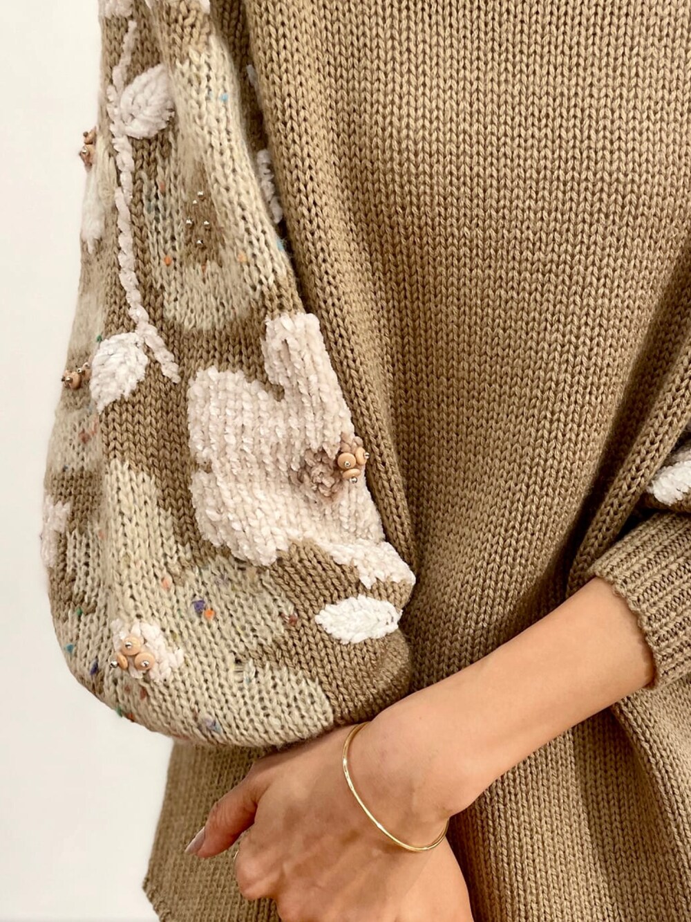 ベージュ系のニット/セーターを着用したレディースの夏コーディネートの3枚目の写真