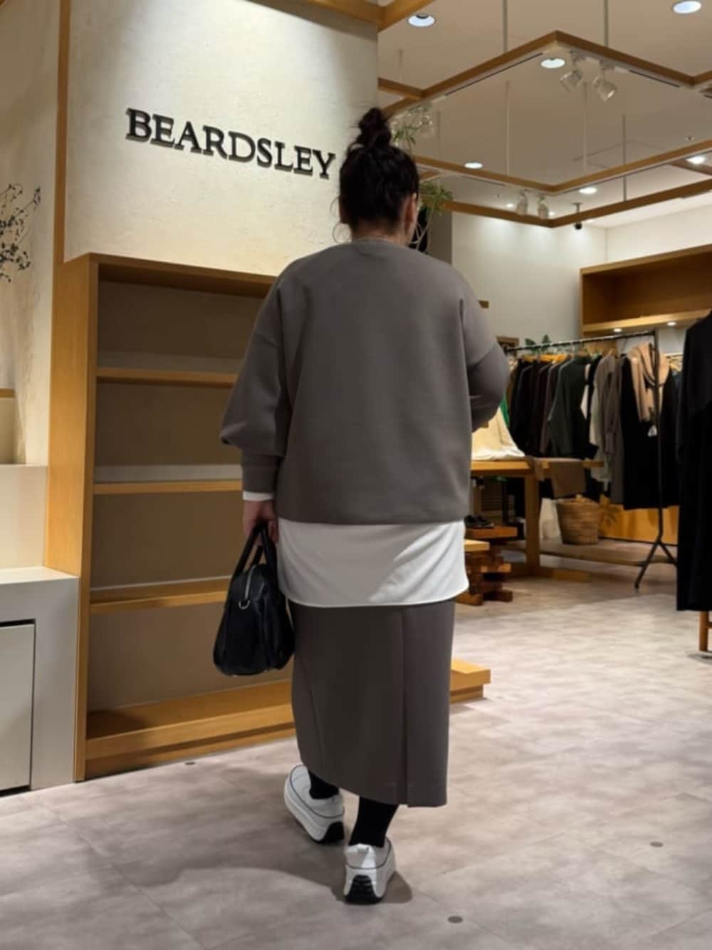 ホワイト系のスニーカー、ブラック系のボストンバッグ、ホワイト系のシャツ/ブラウスを着用したレディースの冬コーディネートの3枚目の写真