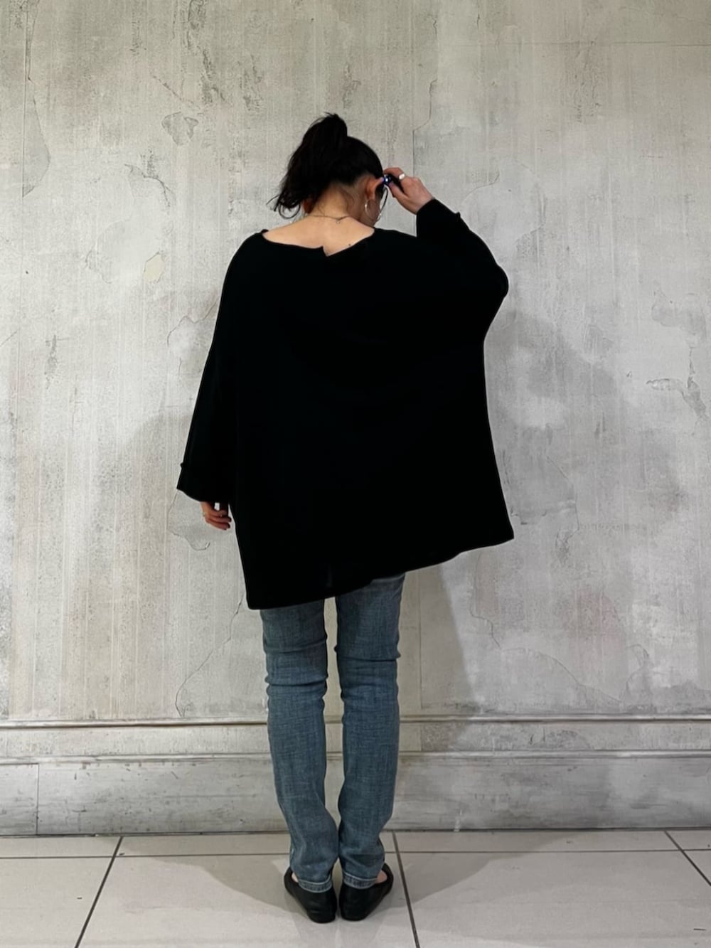 ブルー系のデニムパンツ、ブラック系のハンドバッグ、ブラック系のTシャツ/カットソーを着用したレディースの春コーディネートの5枚目の写真