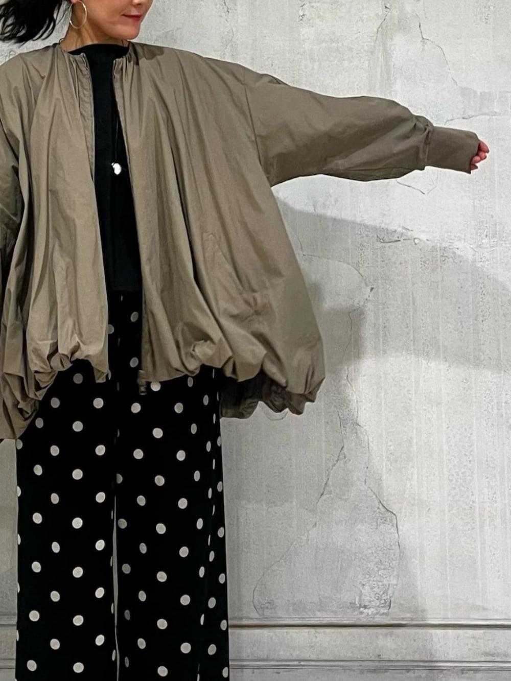 ブラック系のハンドバッグ、ブラック系のその他パンツ、ブラウン系のブルゾンを着用したレディースの春コーディネートの7枚目の写真