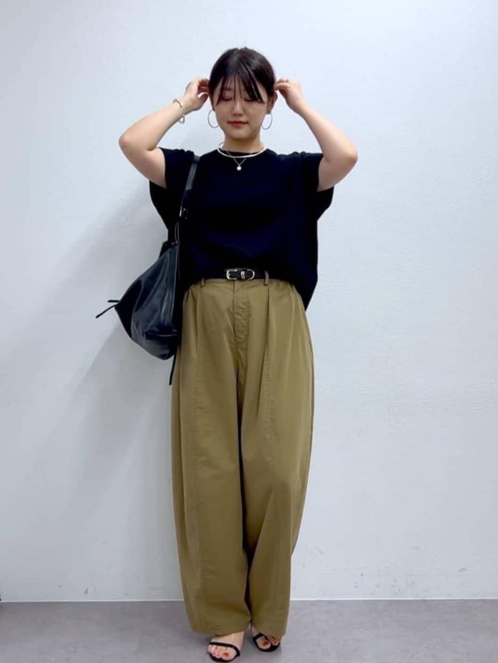 イエロー系のその他パンツ、ブラック系のニット/セーターを着用したレディースの夏コーディネートの6枚目の写真