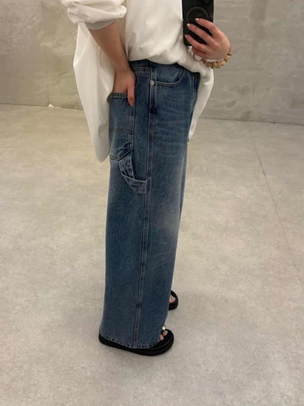 ホワイト系のショルダーバッグ、ブラック系のサンダル、ブルー系のその他パンツを着用したレディースの冬コーディネートの10枚目の写真