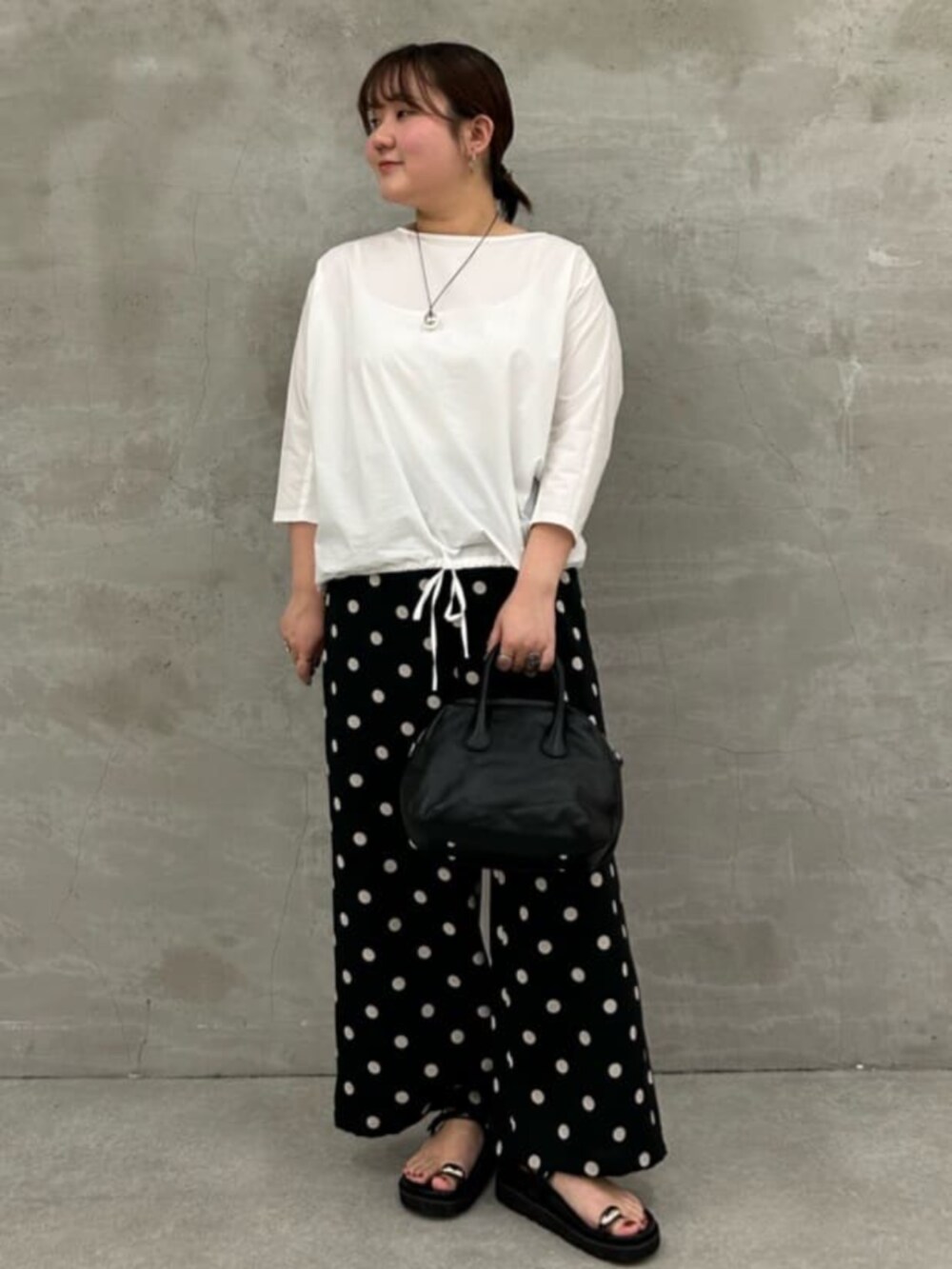 ブラック系のボストンバッグ、ホワイト系のシャツ/ブラウス、ブラック系のその他パンツを着用したレディースの冬コーディネートの2枚目の写真