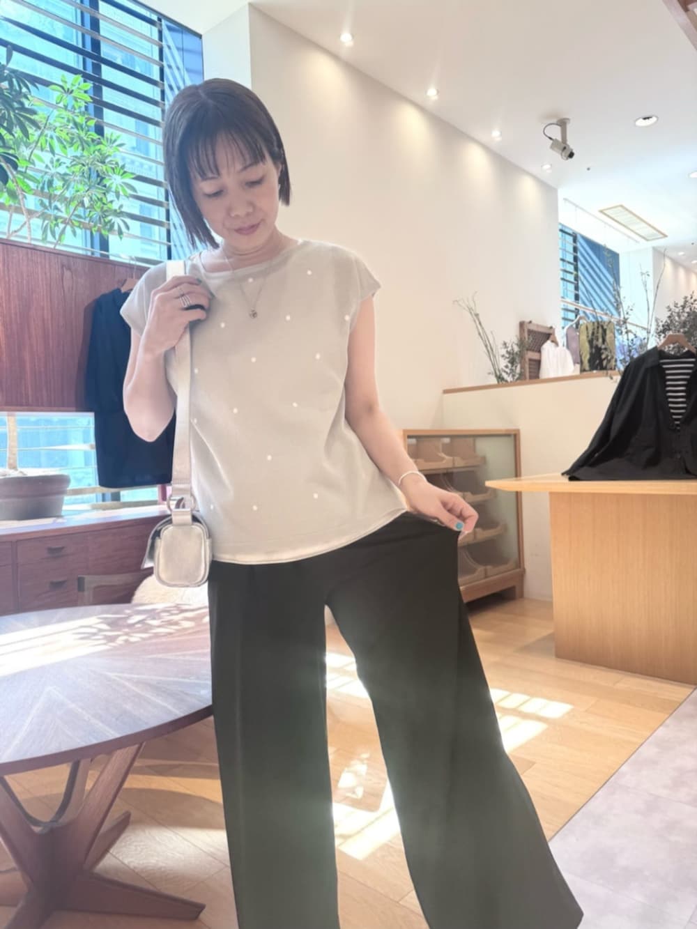 シルバー系のショルダーバッグ、ブラック系のその他パンツ、グレー系のニット/セーターを着用したレディースの春コーディネートの5枚目の写真