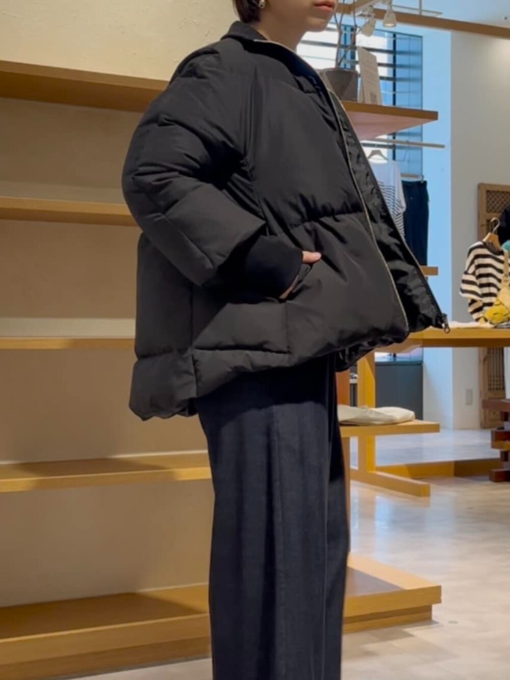 ブルー系のその他パンツ、グレー系のニット/セーター、ブラック系のダウンジャケット/コートを着用したレディースの冬コーディネートの6枚目の写真