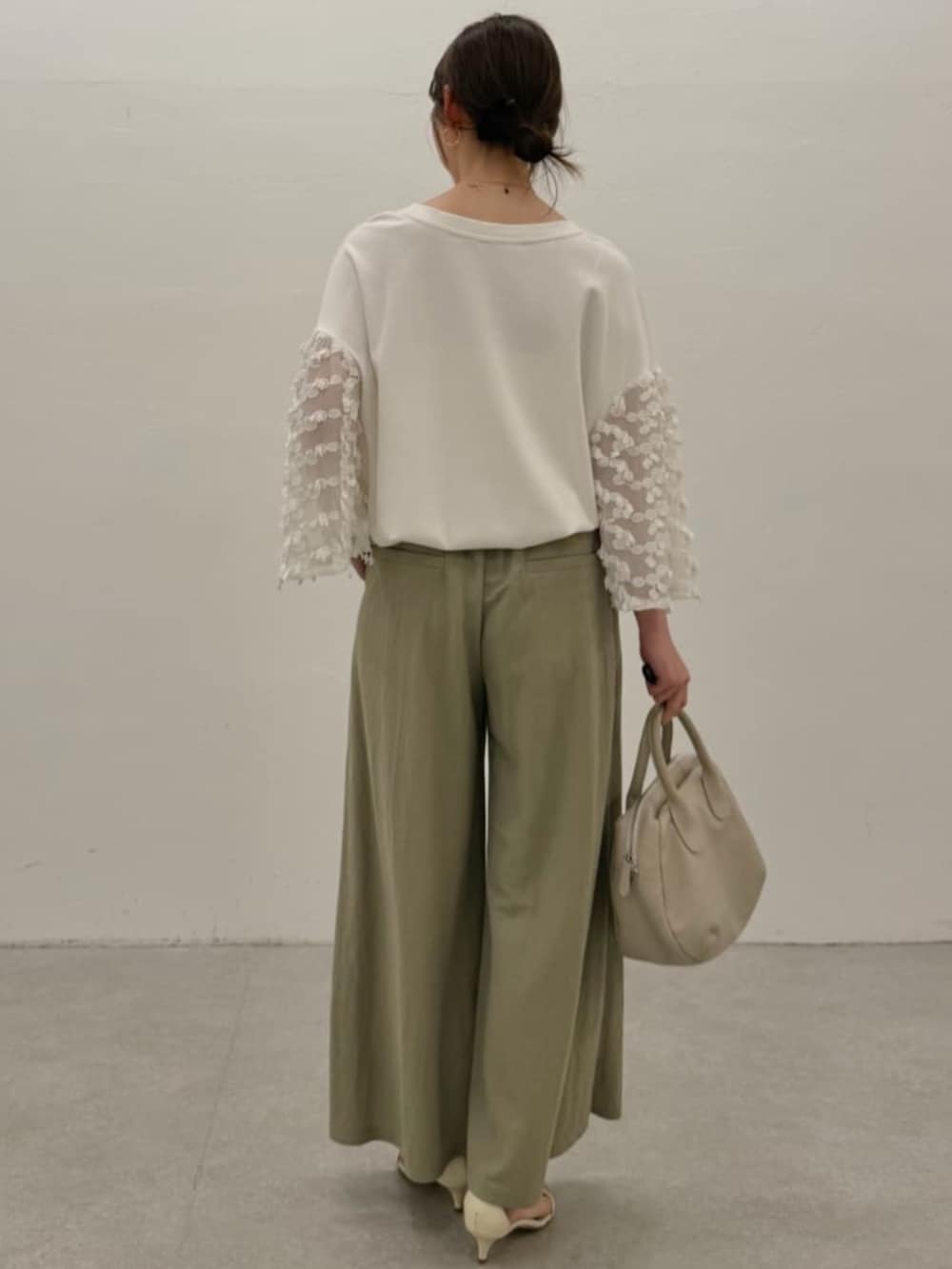 グレー系のボストンバッグ、グリーン系のその他パンツ、ホワイト系のTシャツ/カットソーを着用したレディースの春コーディネートの3枚目の写真