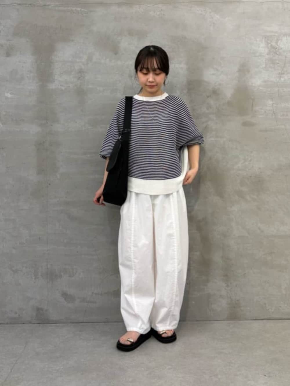 ブラック系のサンダル、ブラック系のショルダーバッグ、ホワイト系のその他パンツを着用したレディースの春コーディネートの2枚目の写真