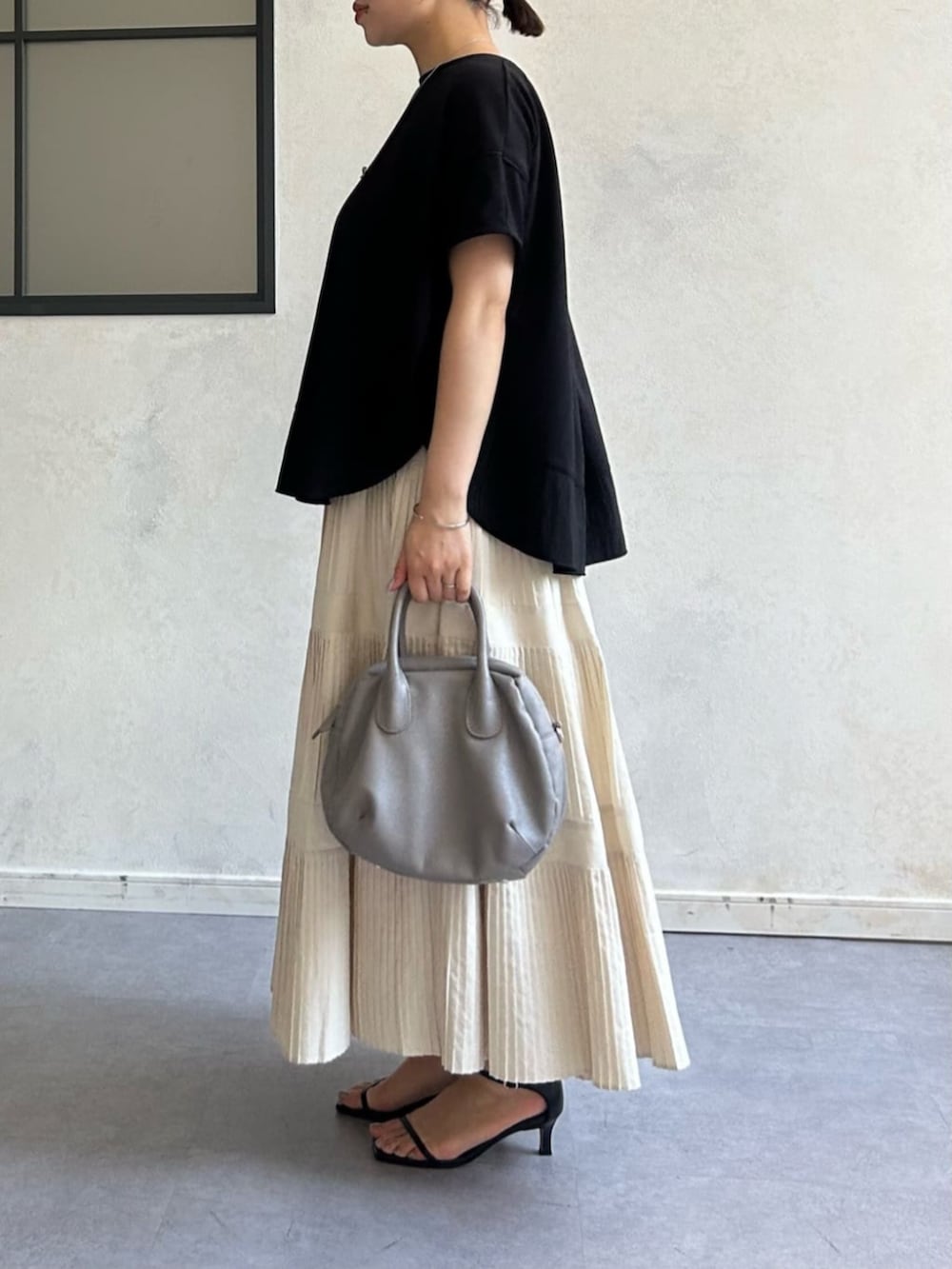 ホワイト系のスカートを着用したレディースの春コーディネートの2枚目の写真