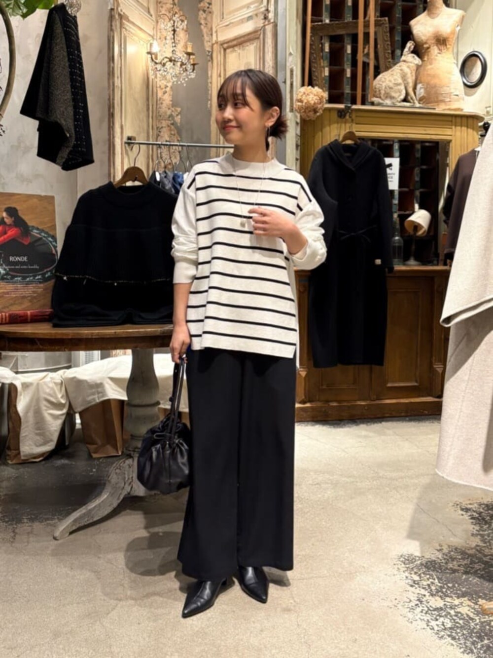 ブラック系のその他パンツ、ホワイト系のニット/セーターを着用したレディースの冬コーディネートの3枚目の写真