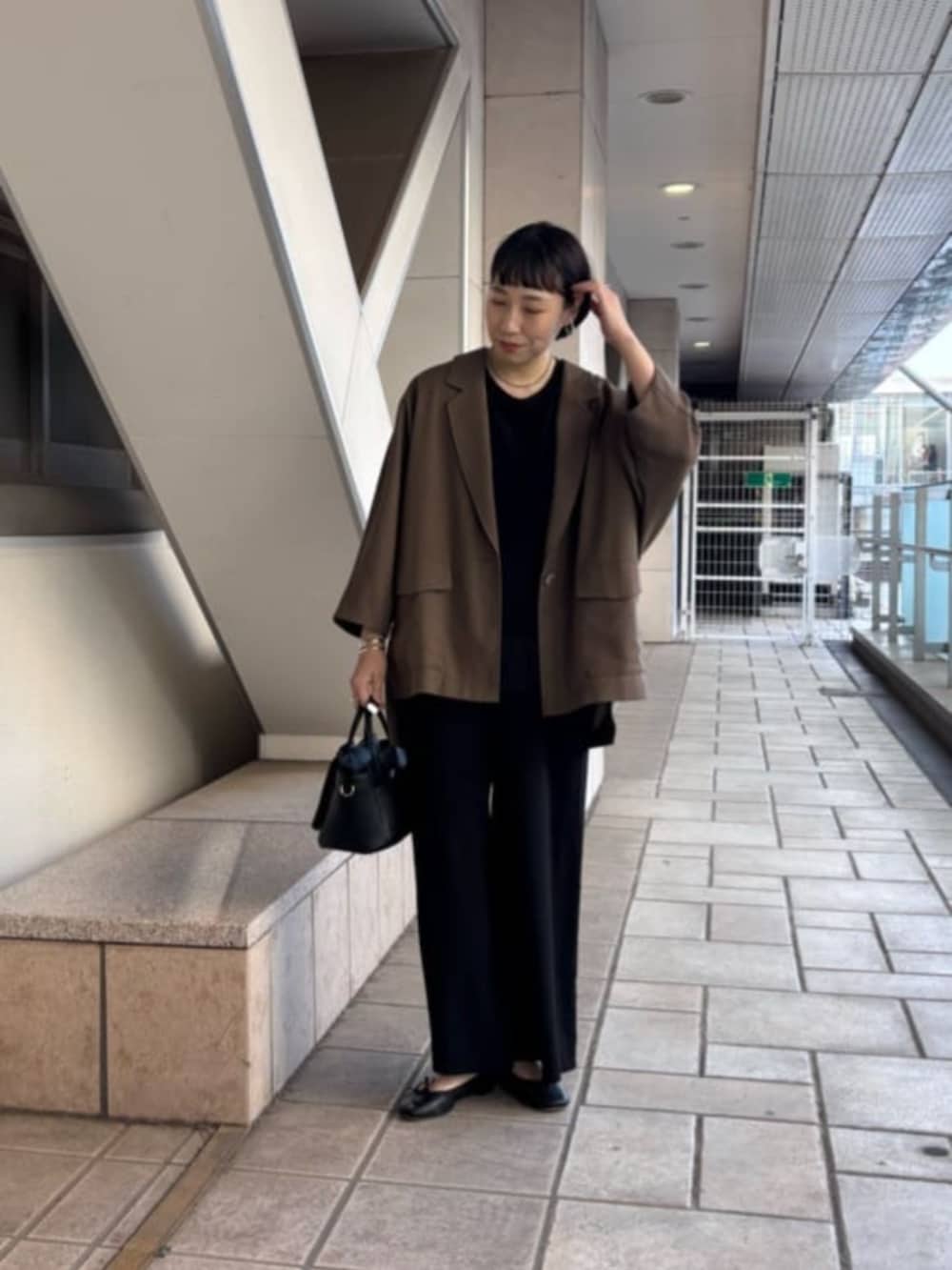 ブラック系のその他パンツ、ブラック系のハンドバッグ、ブラウン系のテーラードジャケットを着用したレディースの春コーディネートの2枚目の写真