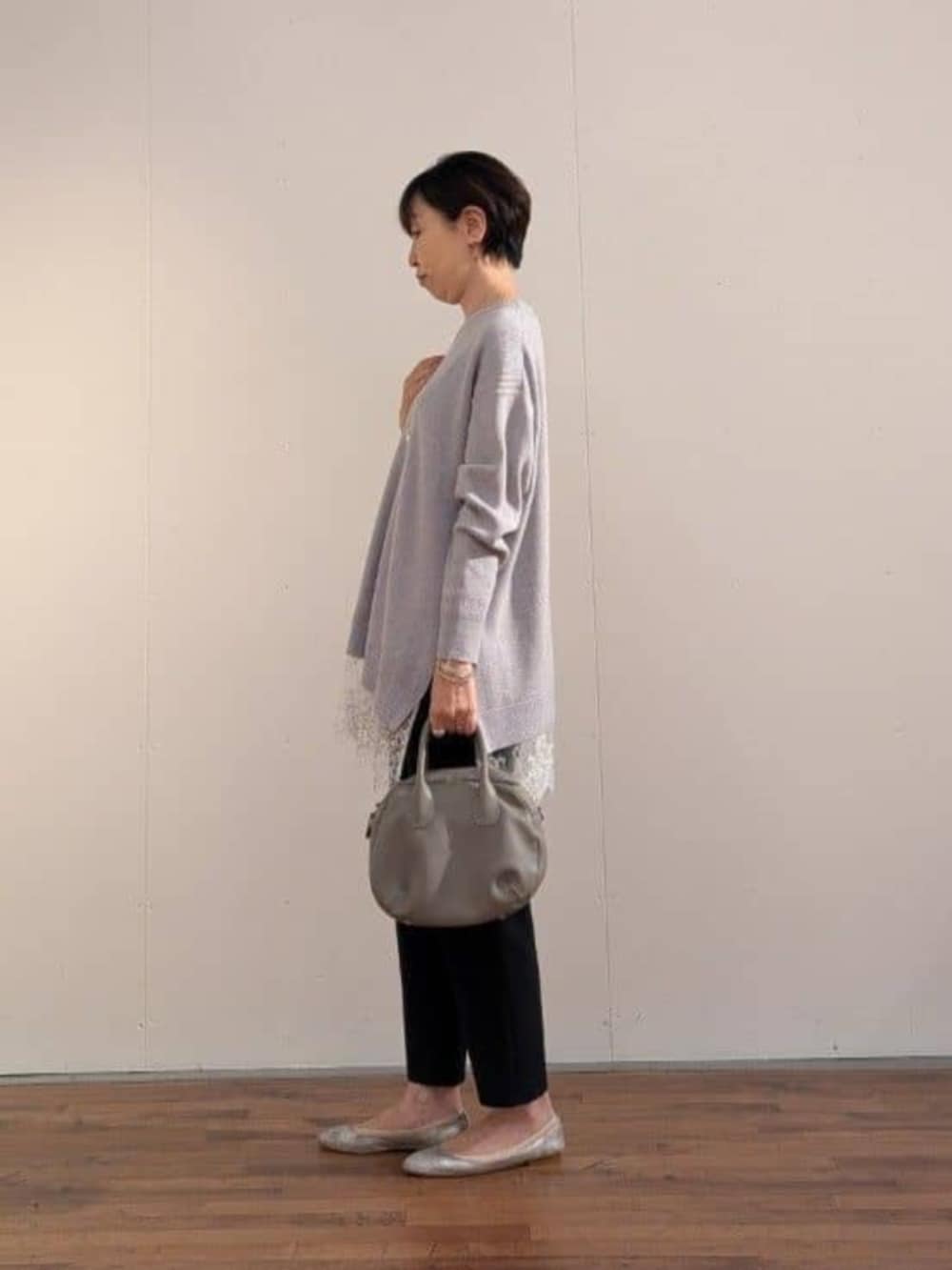 ブラック系のその他パンツ、グレー系のトートバッグ、グレー系のニット/セーターを着用したレディースの秋コーディネートの3枚目の写真