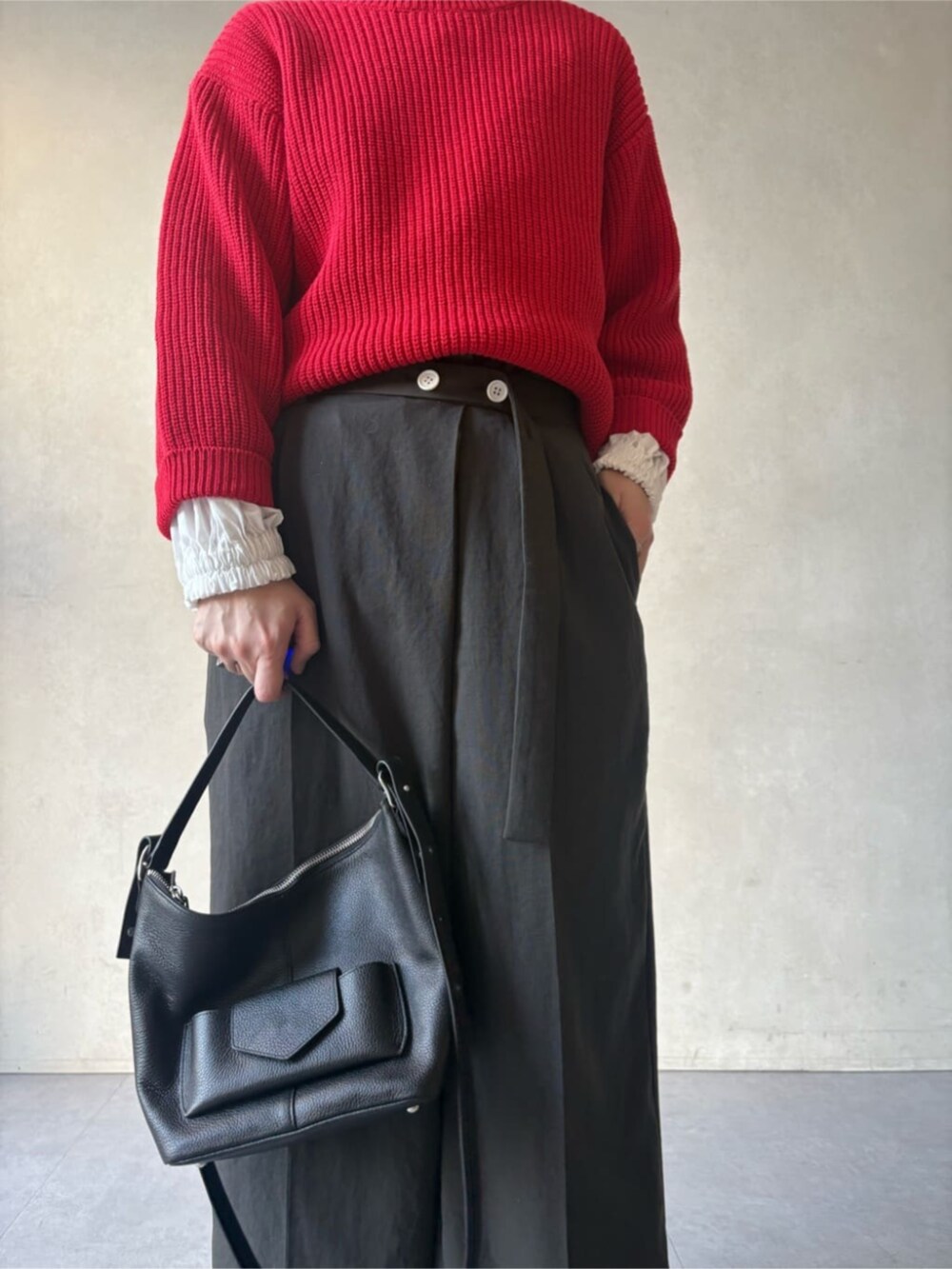 ブラック系のトートバッグ、グレー系のその他パンツ、レッド系のニット/セーターを着用したレディースの冬コーディネートの6枚目の写真