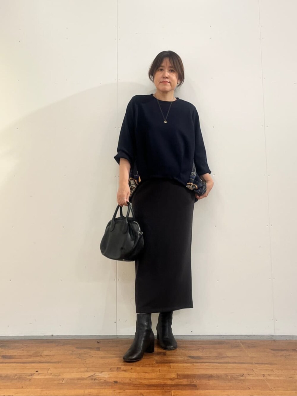 グレー系のスカート、ブラック系のトートバッグ、ブルー系のTシャツ/カットソーを着用したレディースの夏コーディネートの2枚目の写真