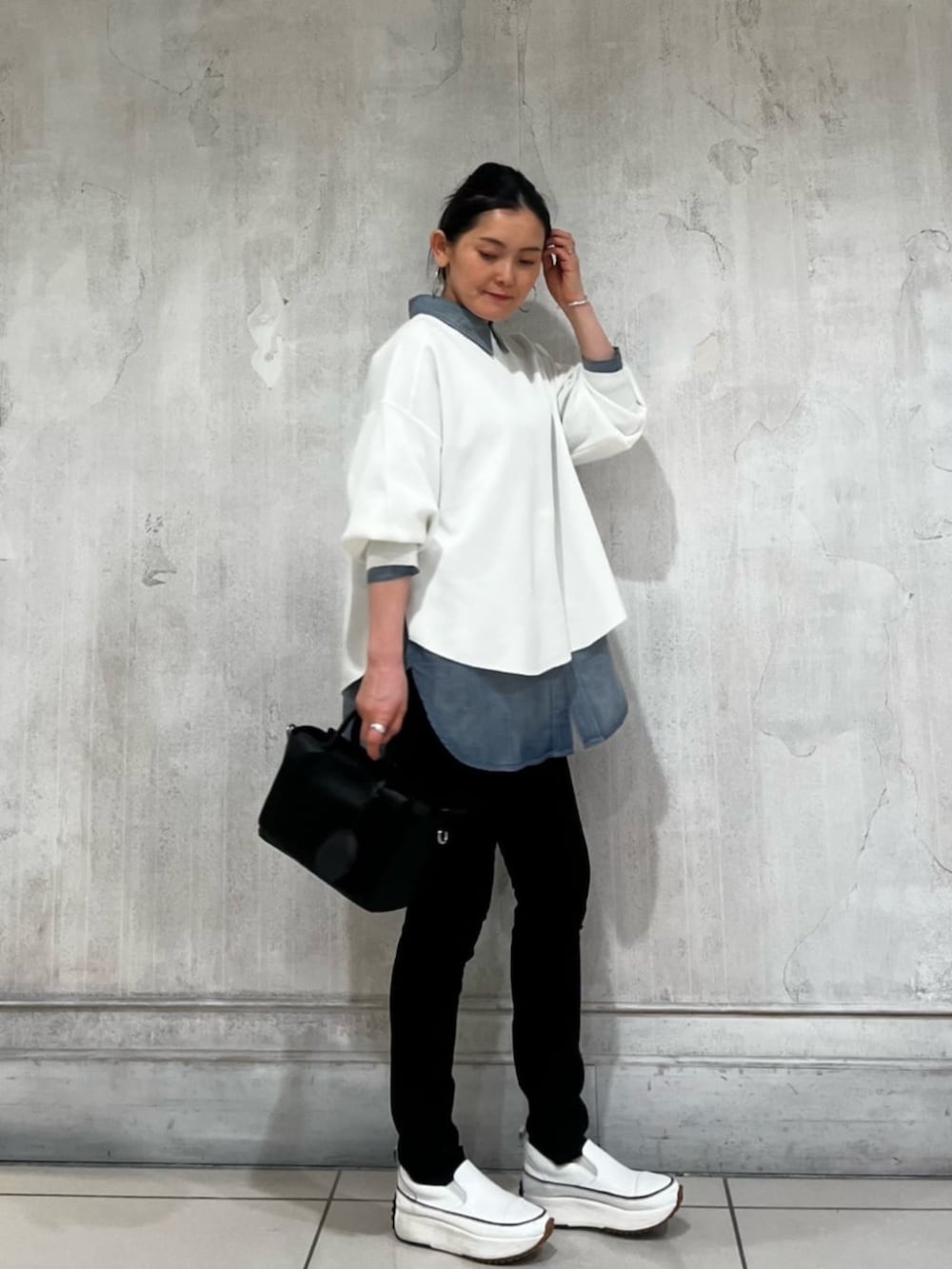 ブルー系のシャツ/ブラウス、ブルー系のデニムパンツ、ホワイト系のTシャツ/カットソーを着用したレディースの春コーディネートの3枚目の写真