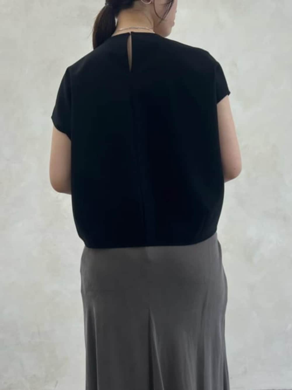 グリーン系のスカート、ブラック系のシャツ/ブラウスを着用したレディースの春コーディネートの7枚目の写真