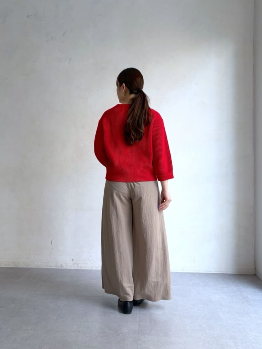 ベージュ系のその他パンツ、レッド系のニット/セーターを着用したレディースの冬コーディネートの3枚目の写真